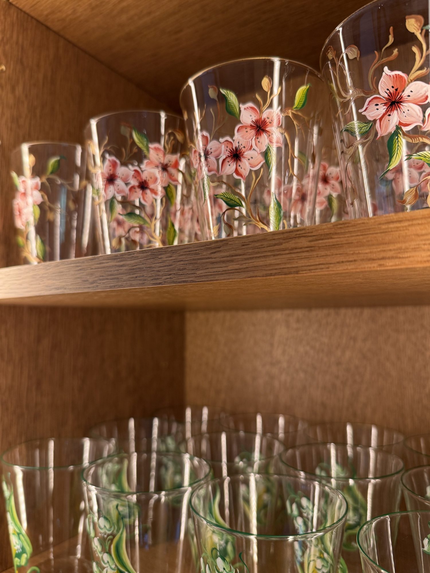 Glassware arranged on cabinet shelves.