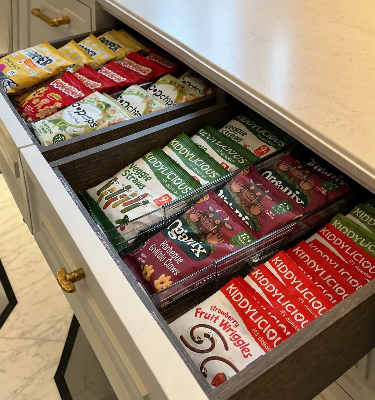 A drawer of snack packets sorted upright by kind.