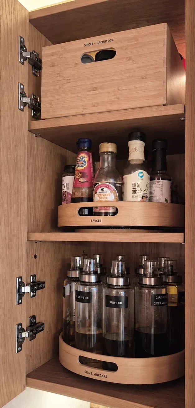 A narrow cupboard with a turntable of bottles and jars.