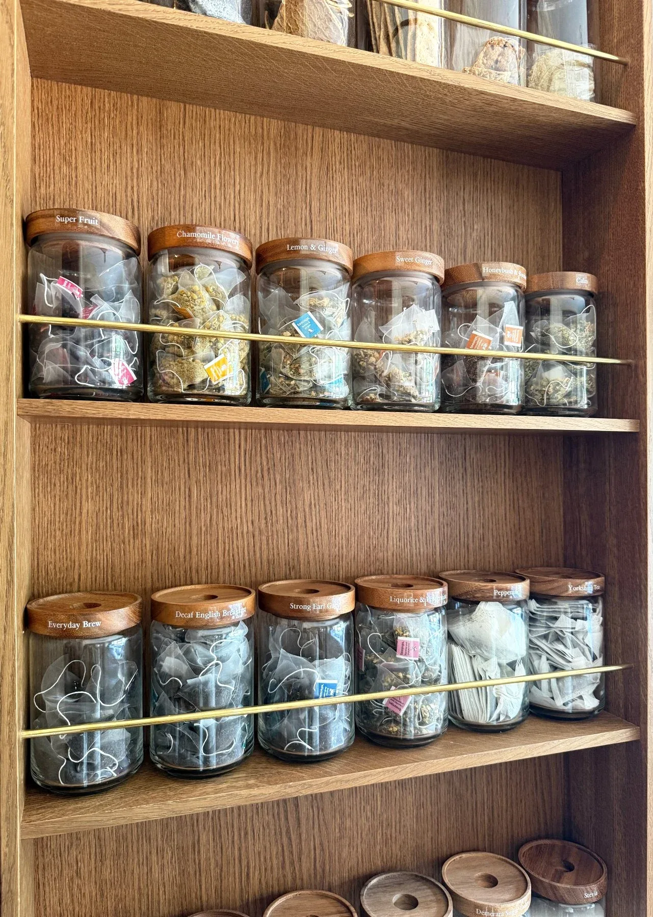 Jars of dried ingredients ranged along open timber shelves.