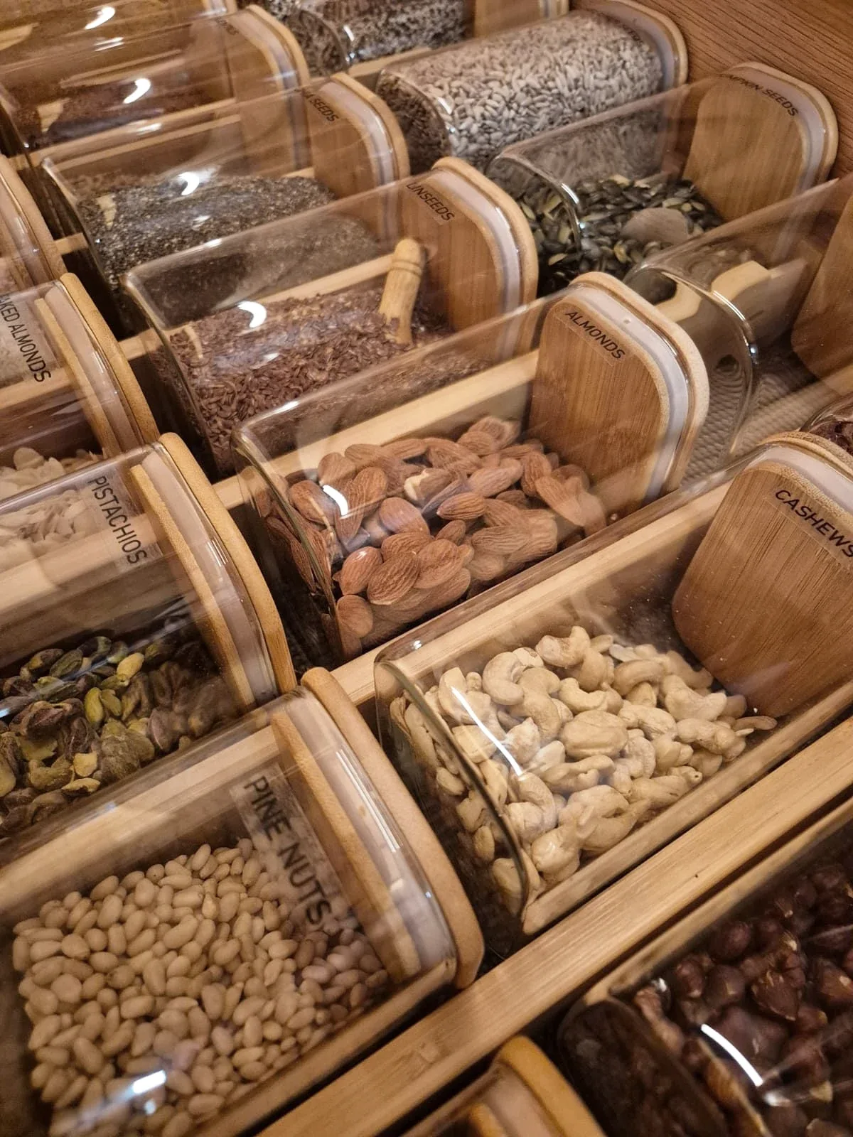 Nuts and dried fruit in jars set into a timber drawer insert.