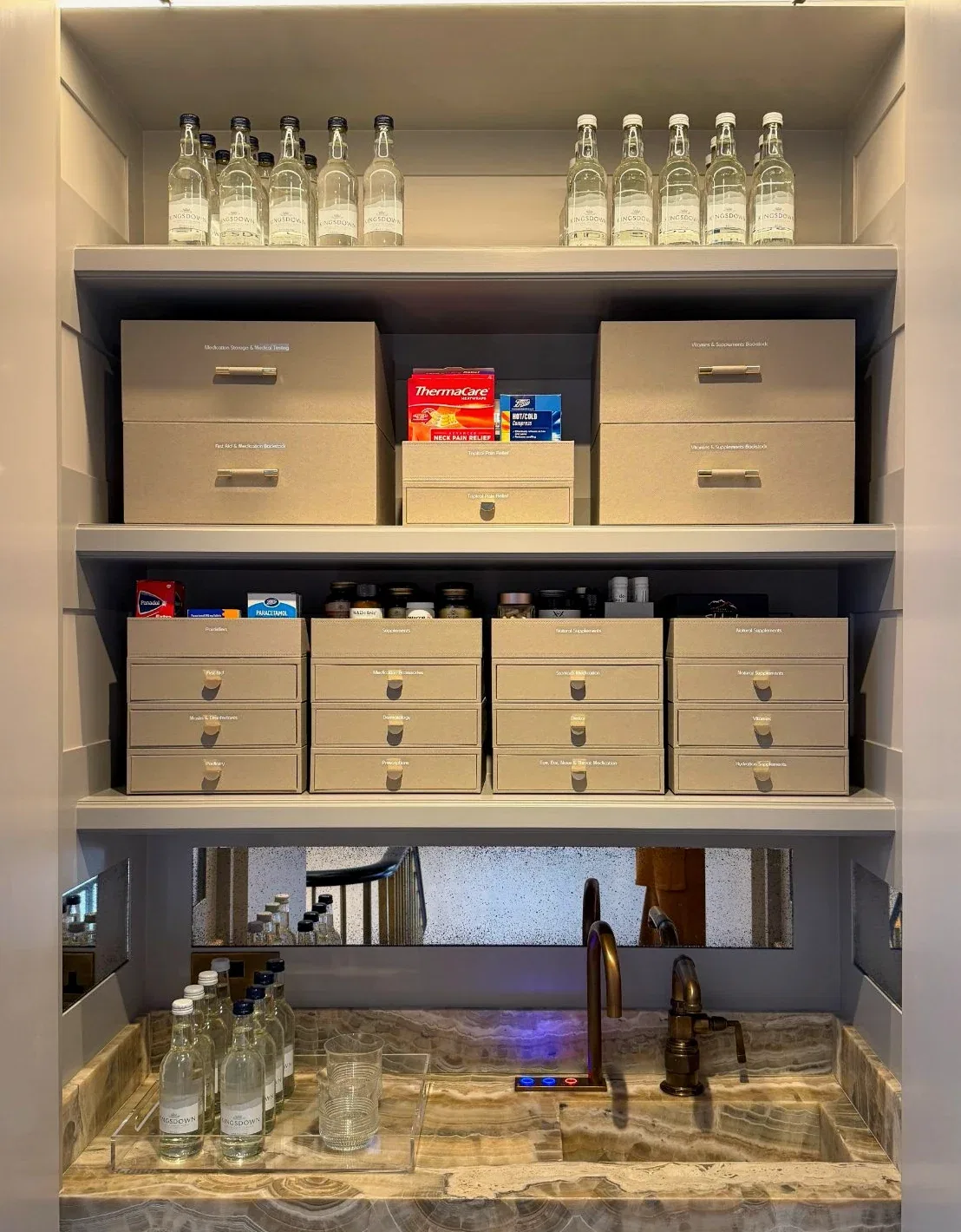 A tall pantry cupboard of labelled boxes, bottles and baskets.