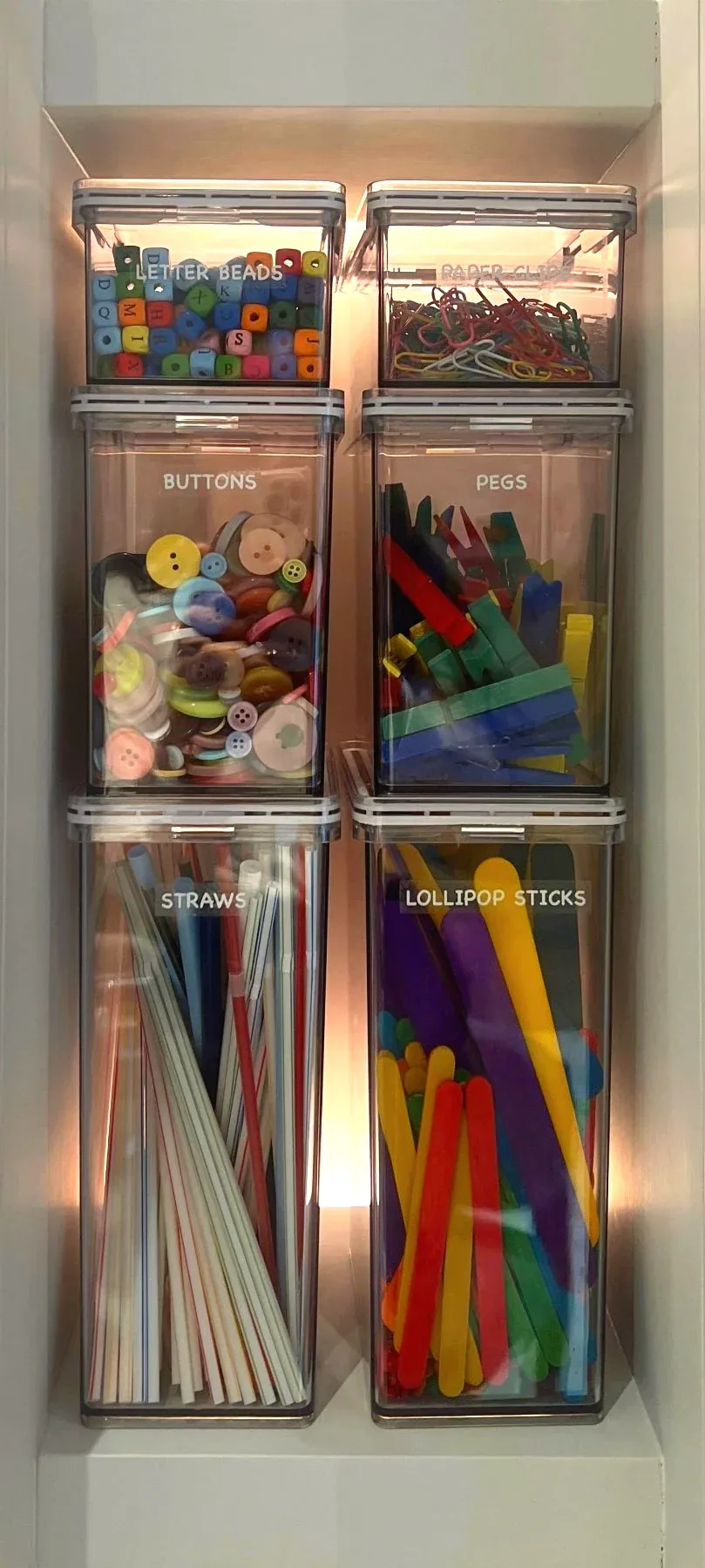 Clear drawers of craft materials and coloured paper.