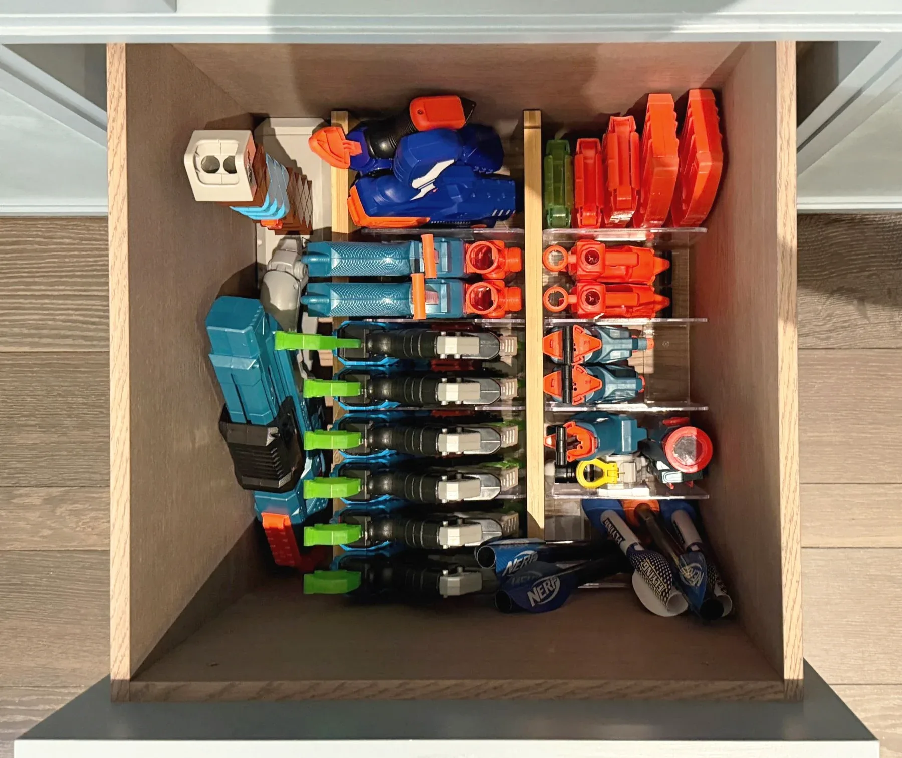 Toy blasters racked upright inside a cupboard.