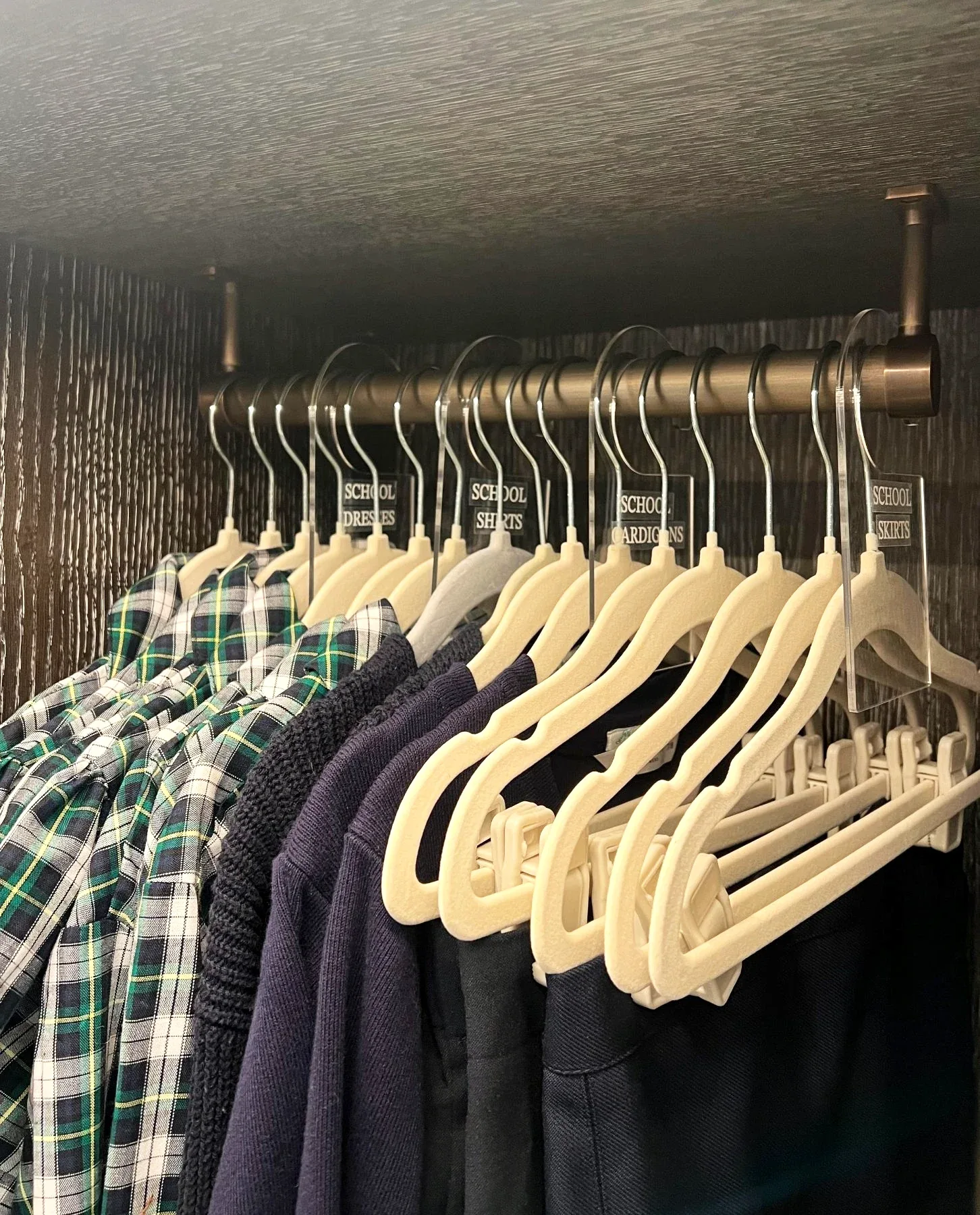 Checked shirts on matching wooden hangers.