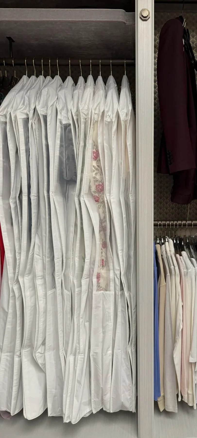 White shirts hanging in a row in a wardrobe.