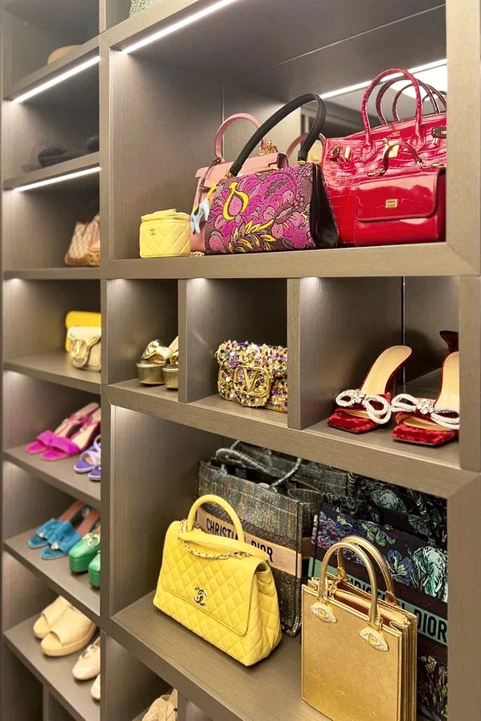 Handbags and shoes arranged across lit open shelving.