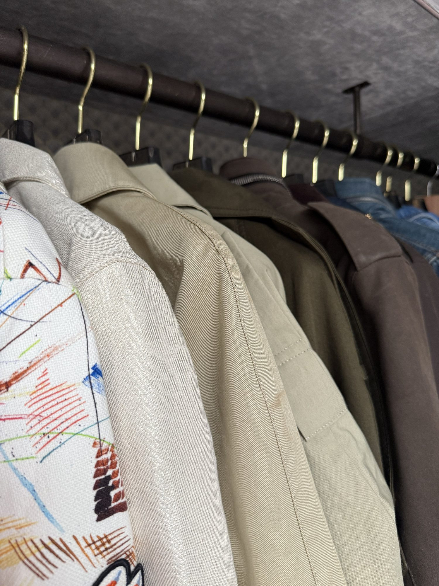 Jackets hung along a wardrobe rail.