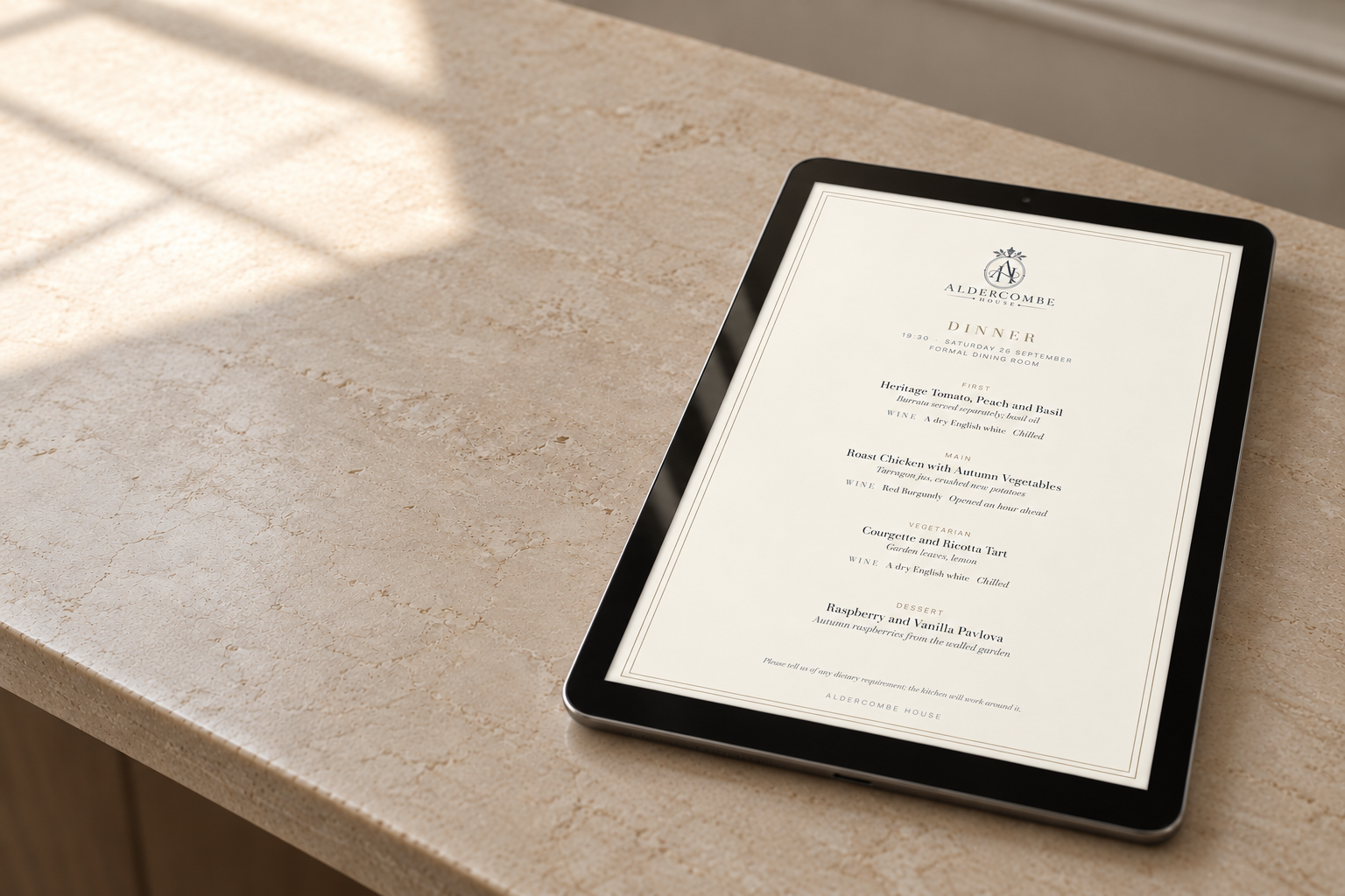 A dinner menu shown on an iPad resting on a marble table in daylight.