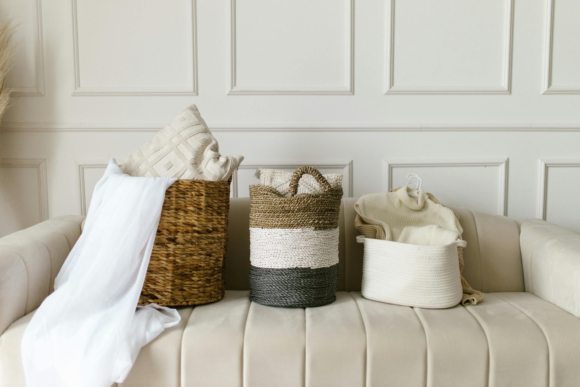 Woven baskets of linen on an upholstered bench.