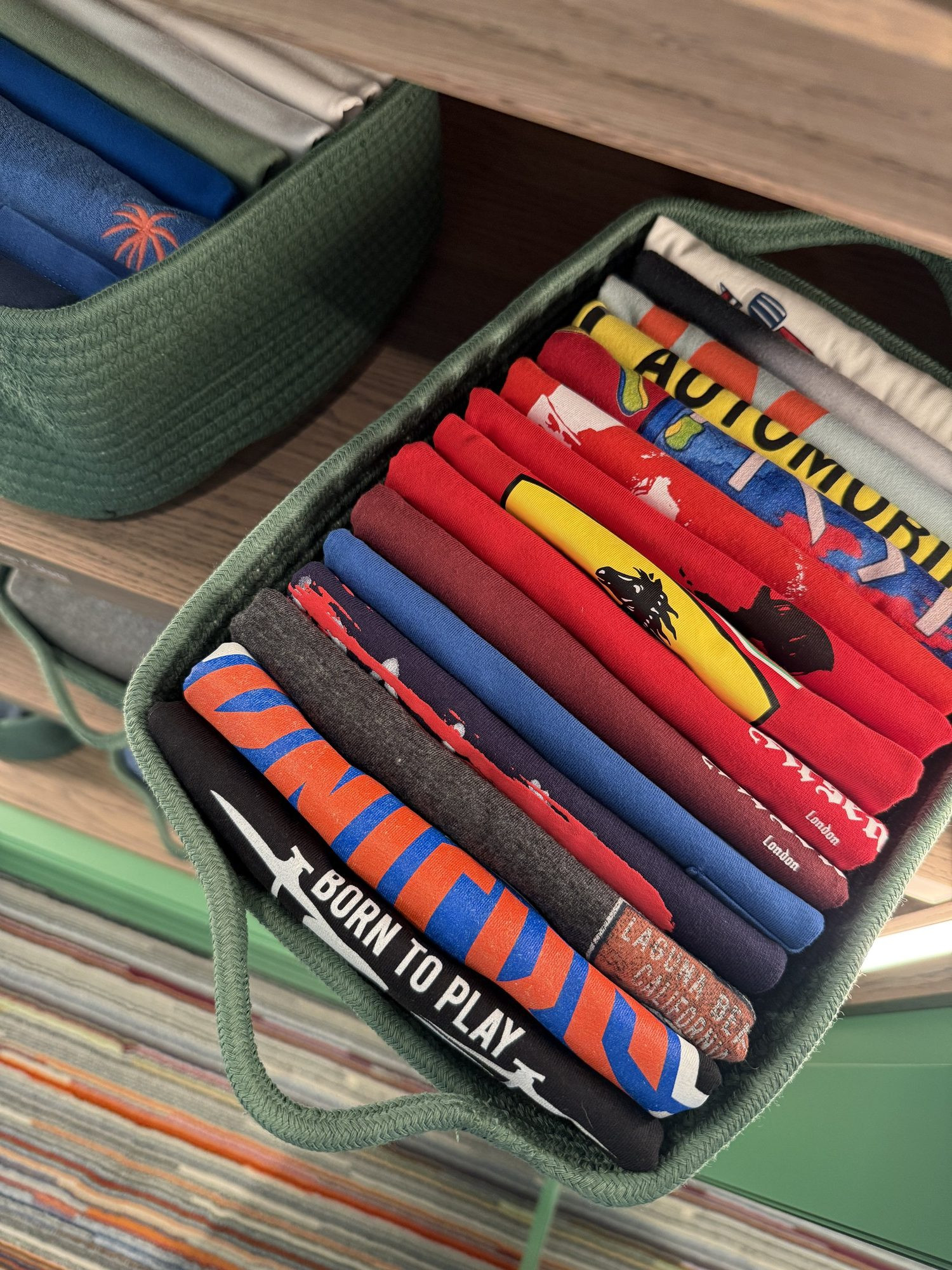 Children's clothes folded into a woven basket.